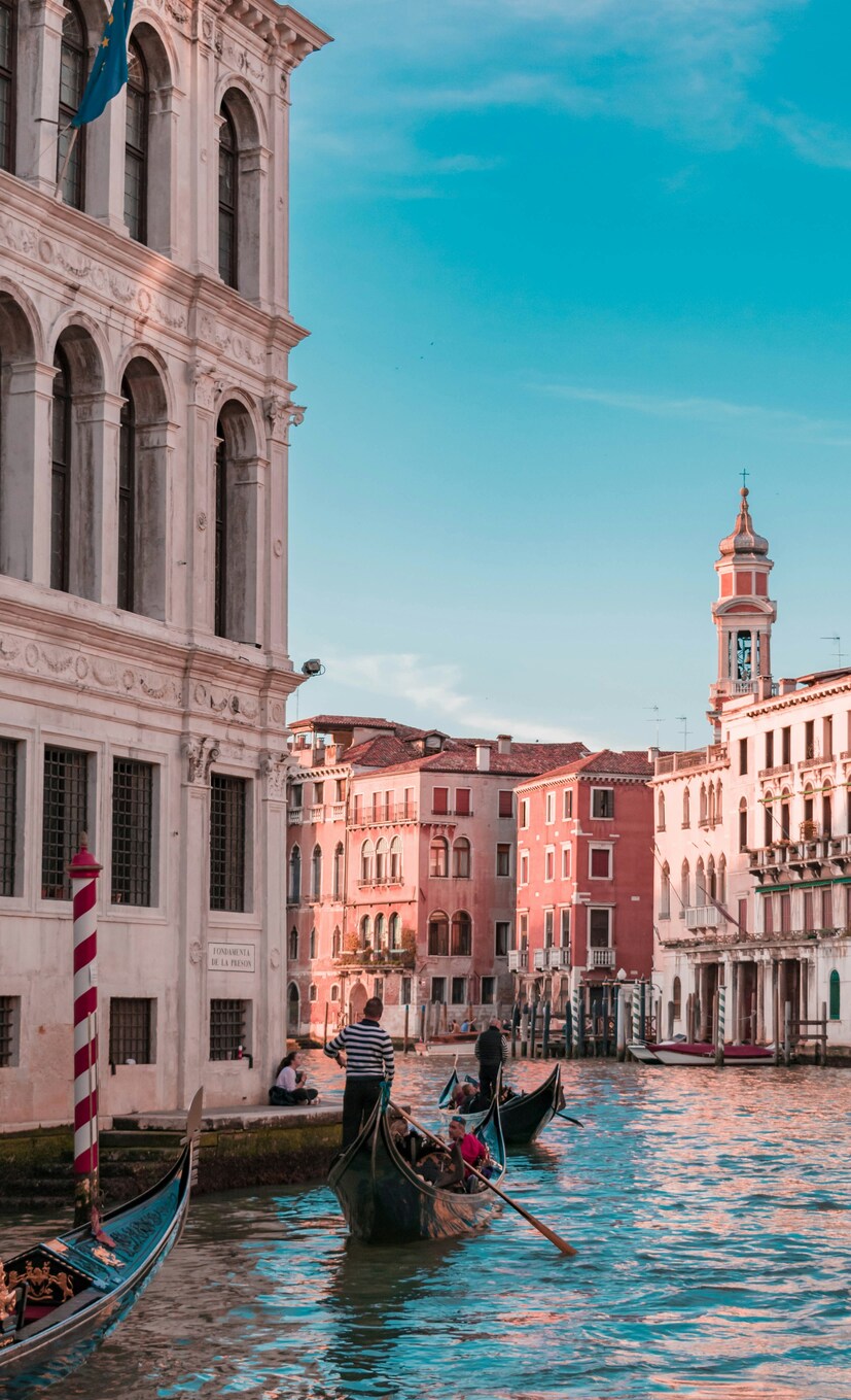Gondolas passing pastel palazzi on a Venetian canal