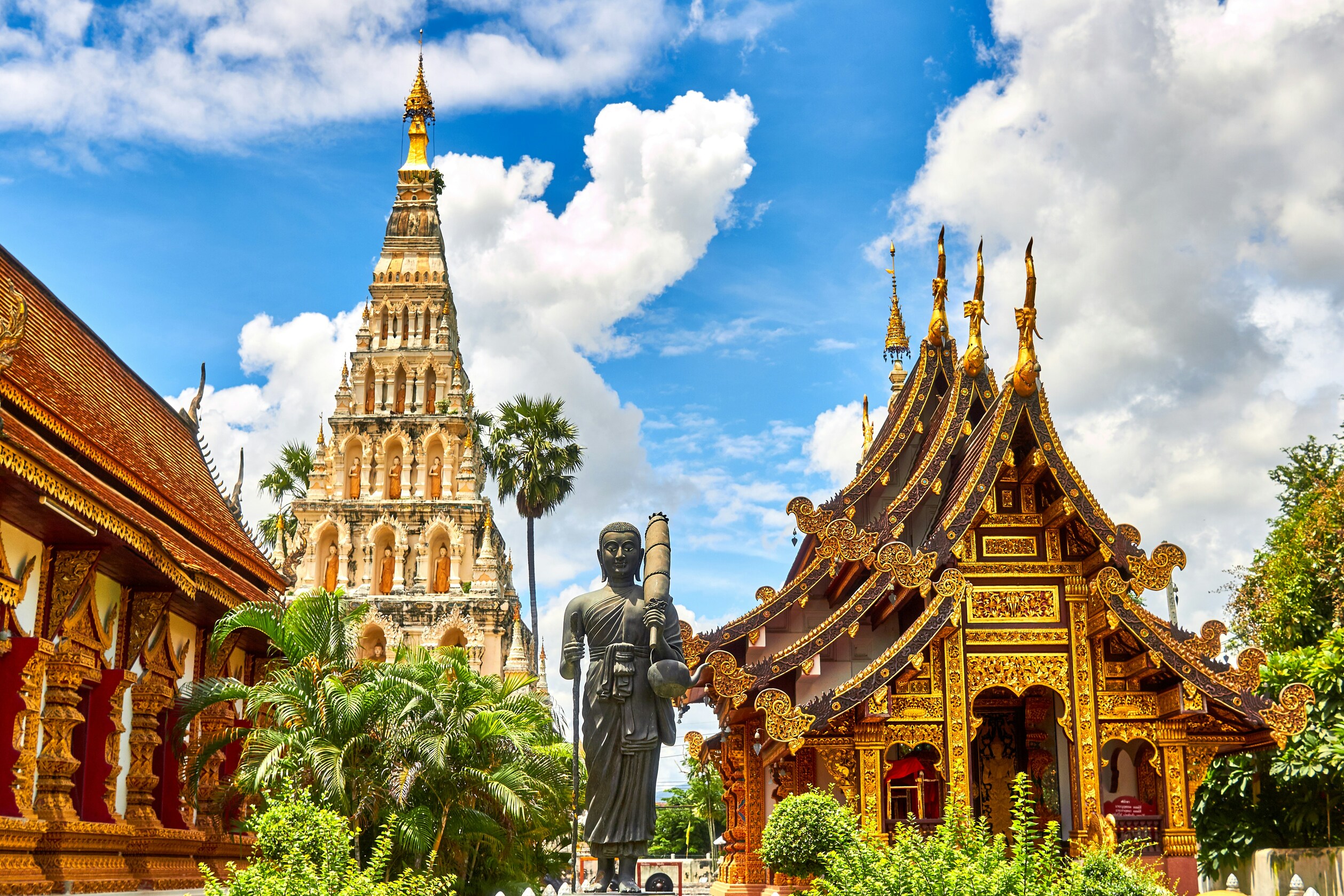 Golden temple spires under a bright blue sky in Thailand
